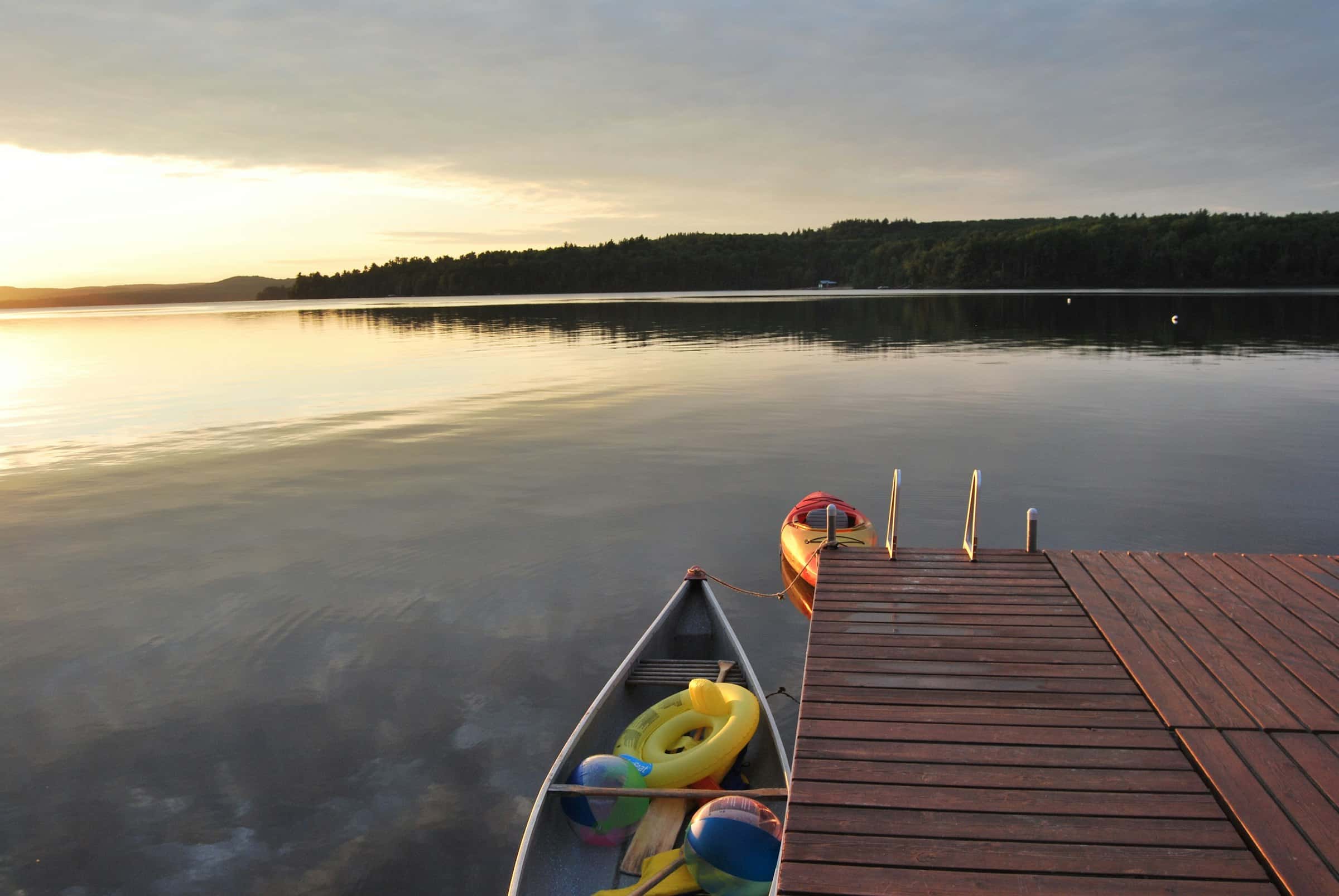 A rowboat tied to a dock at sunrise in Kawartha Lakes
